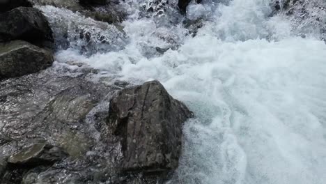 raging waterfall cascading down mountain is slow motion after, aerial drone part 10, buttermere, lake district, uk, drone close up, lower mountain