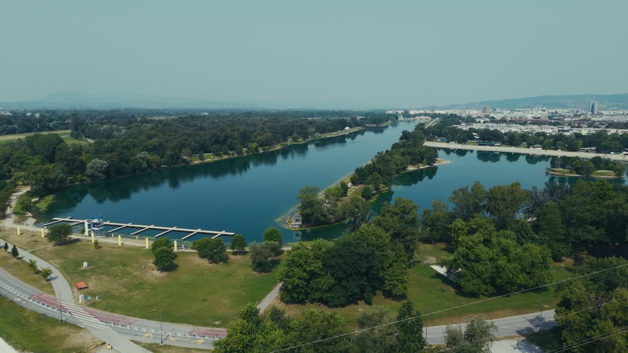 aerial - Jarun Lake with long rowing course, small islands, and surrounding city roads