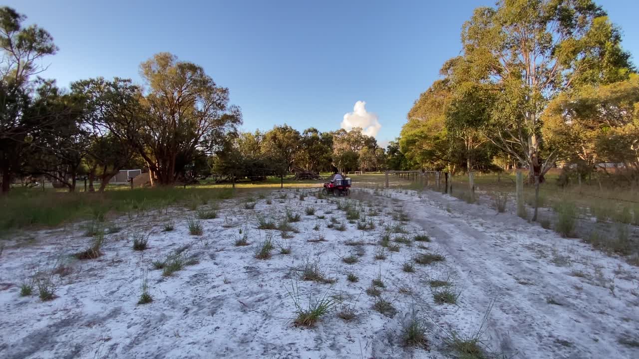 hombre en quad maquinaria agrícola montando conduciendo hacia la cámara