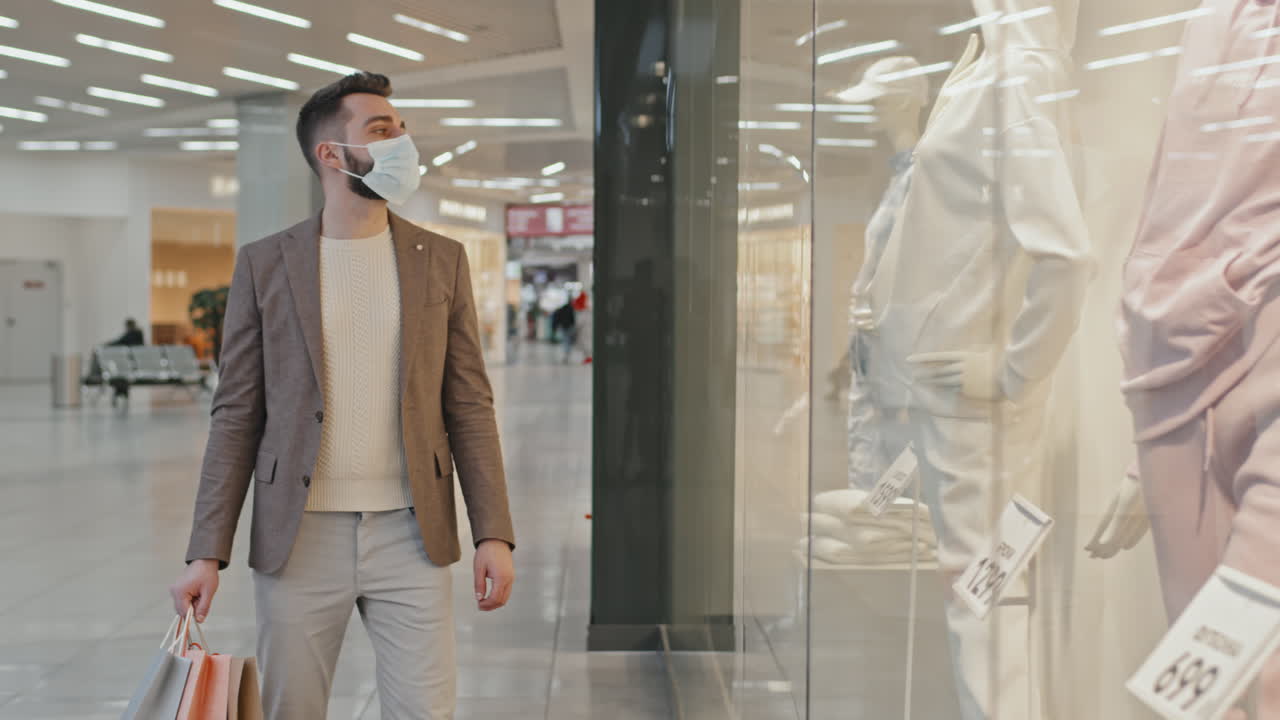 Handsome Man in Face Mask Walking Along Shopping Centre