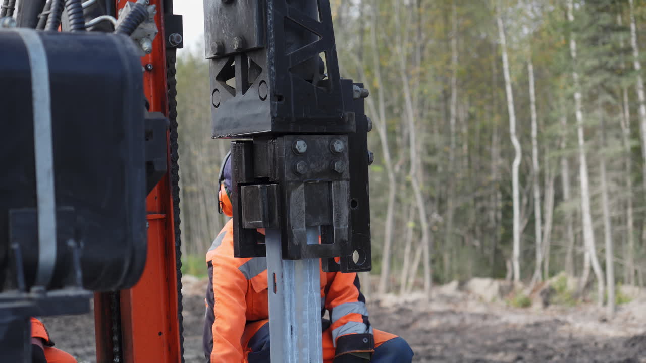 금속 기둥을 설치하는 건설 노동자