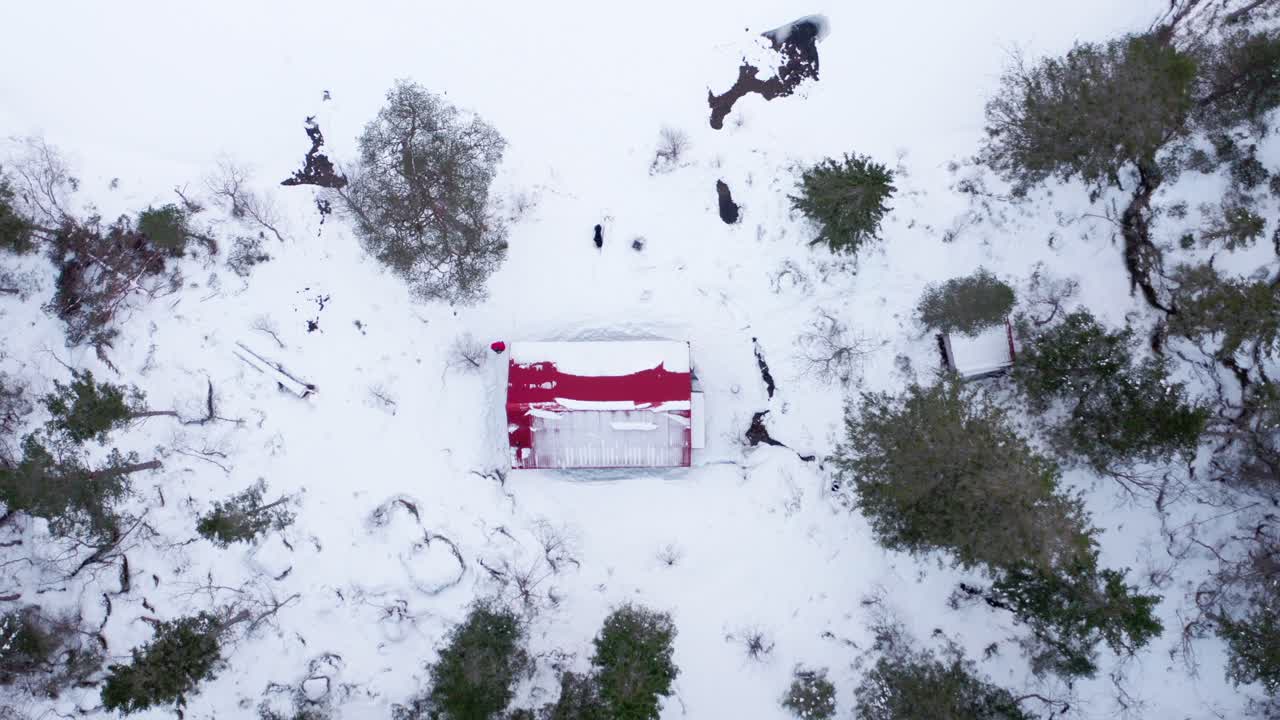 drone ascendiendo en una cabaña en el bosque de invierno en las montañas
