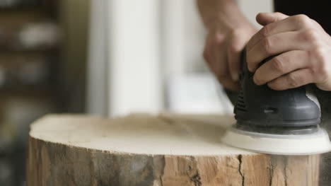 carpintero lijando madera en el taller 1