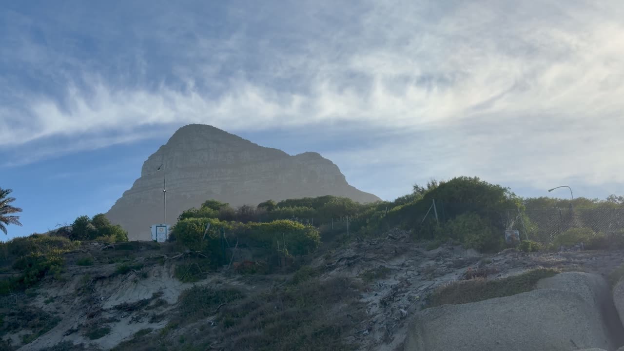 Lions Head che fa capolino dietro le rocce a Maidens Cove, vicino a Camps Bay, Città del Capo.