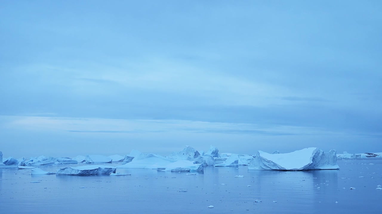 Blaue Meereisberge und Meereslandschaft in der Antarktis, Eisberg in der Blauen Stunde schwimmt auf dem Wasser der Antarktischen Halbinsel, eine wunderschöne Winterlandschaft, minimalistischer Hintergrund mit Platz für Text.