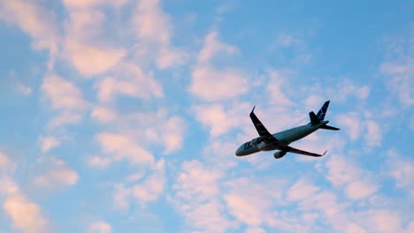 airplane ascending towards destination in cloudy blue evening sky