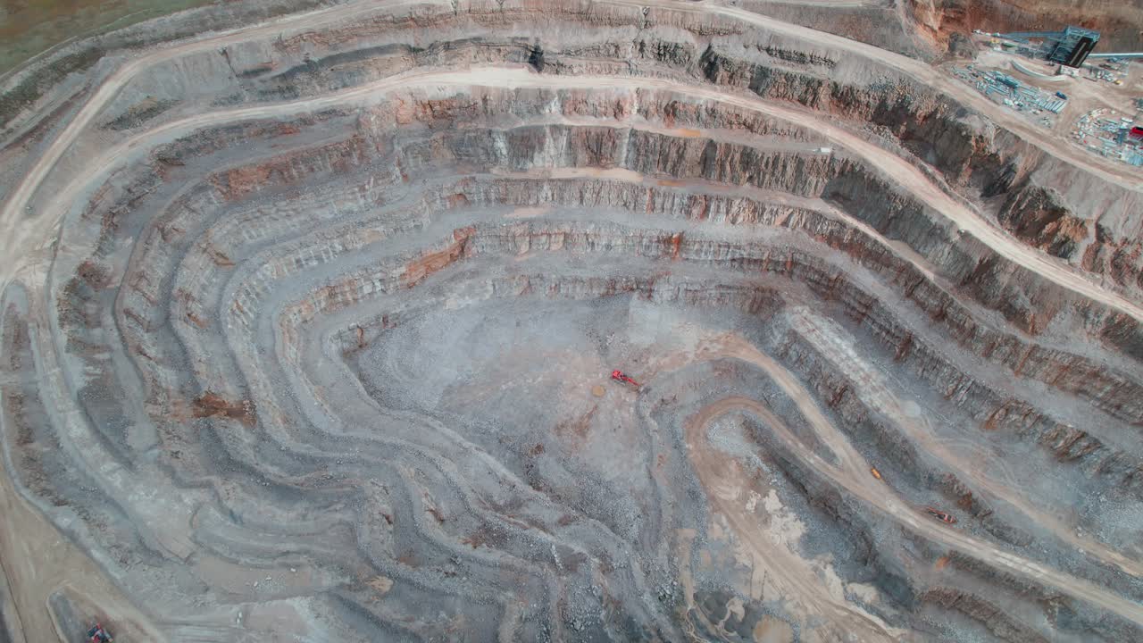 Aggregate mining in Yorkshire quarry aerial view top down tilting upwards to countryside scenery