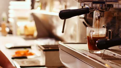 coffee being poured in the cup from coffee maker