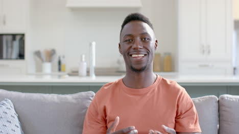 Happy-african-american-man-having-video-call-in-sunny-living-room,-slow-motion