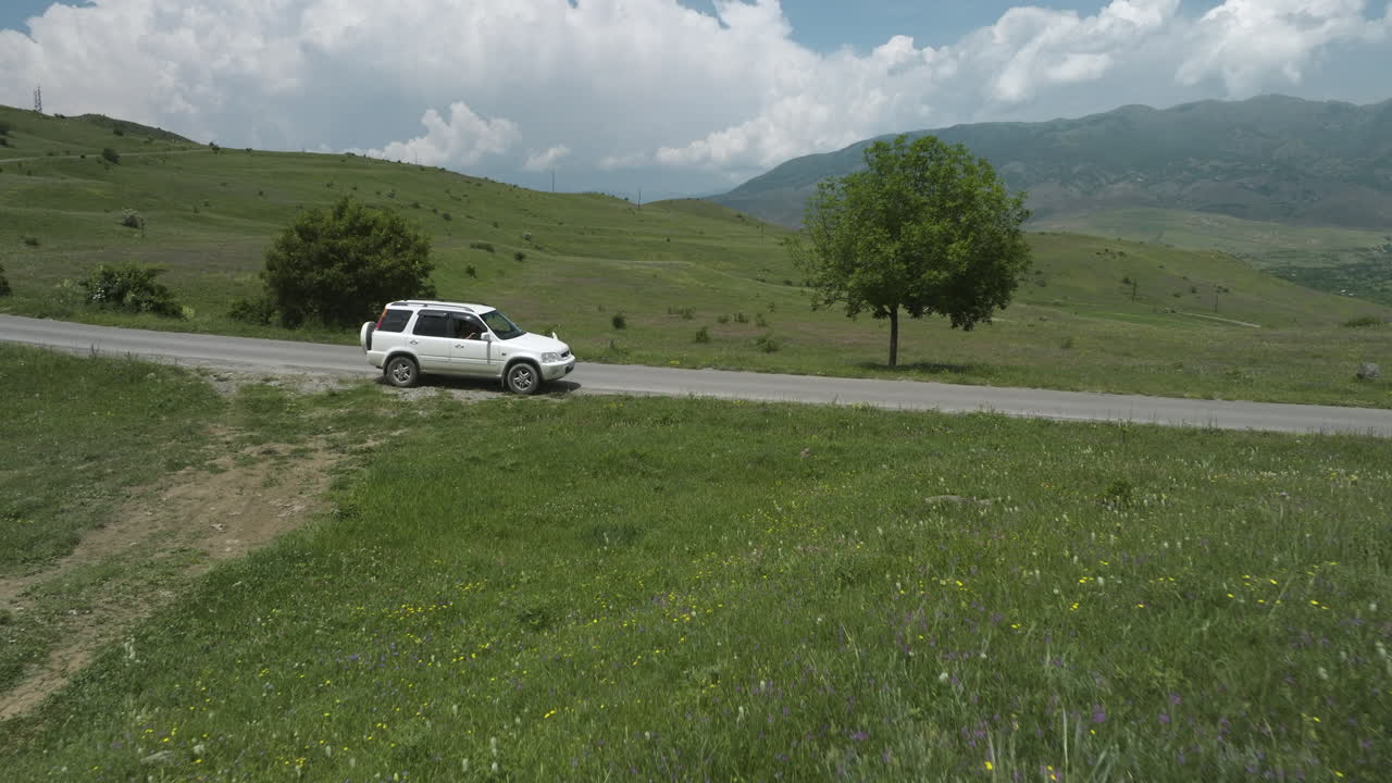 남부 조지아의 아스핀자 외부 잔디밭 사이 시골길에 주차된 흰색 차