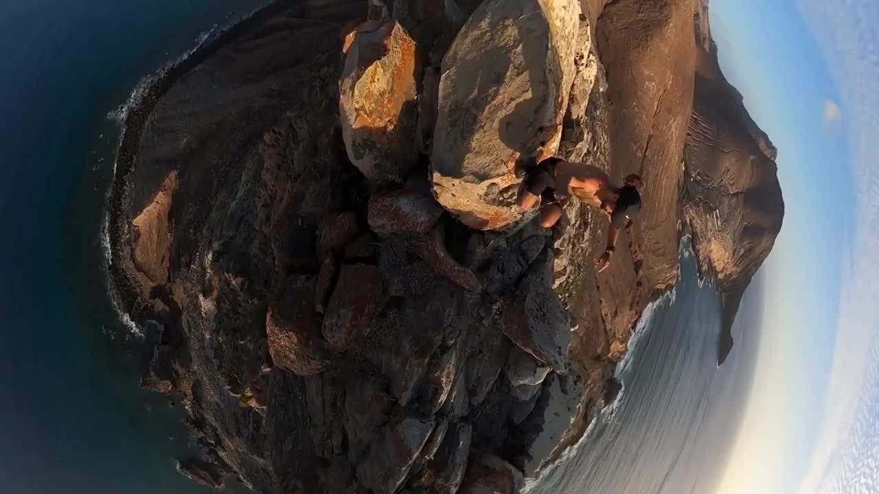 Vertical 360 footage of a man hiking on the cliff on Porto Santo island in the sunset