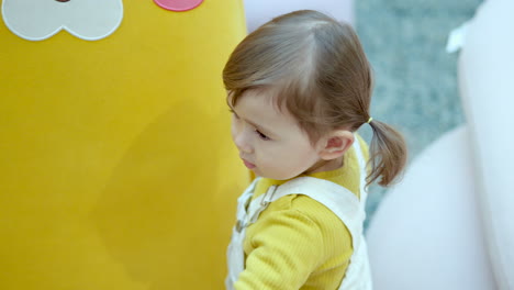 three-year-old female kid at the play area of a shopping mall