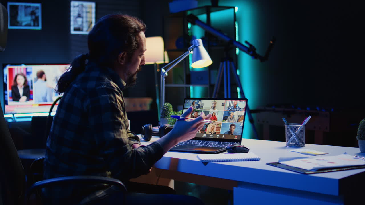 아파트 사무실에서 비디오 통화 중에 동료들을 인사하는 원격 노동자