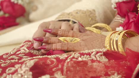 close-up of hands with traditional henna and gold jewelry at an indian wedding