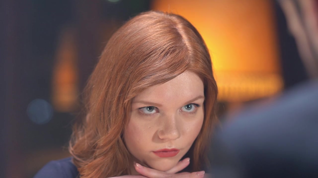 Close-up of Young Redhead Woman Looking Up with Intense Gaze