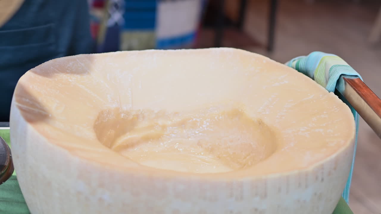 Uomo che mette la pasta in una forma di parmigiano calda in un ristorante