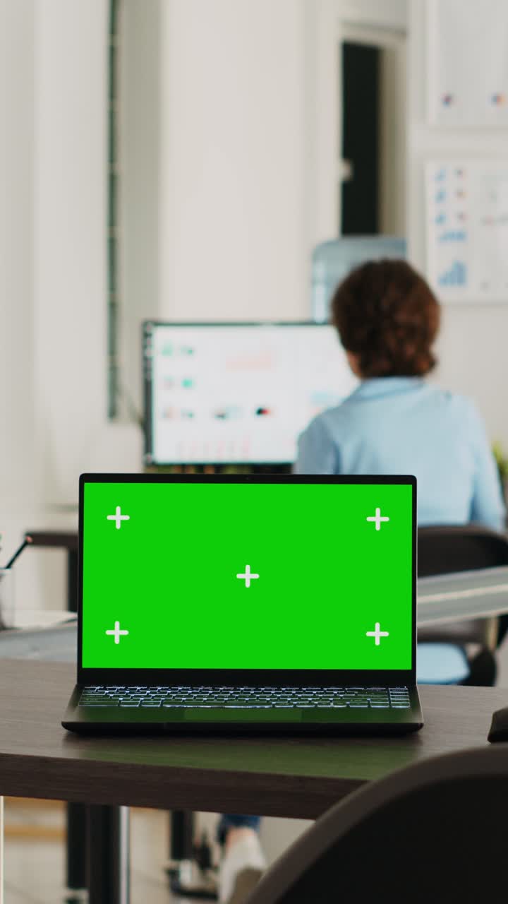Vertical video Laptop with greenscreen display on desk