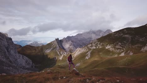 woman is hikeing in the alps - fast parallax drone flight