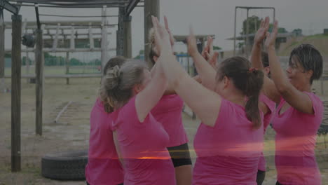 celebrating together, women in pink shirts at outdoor obstacle course with animation