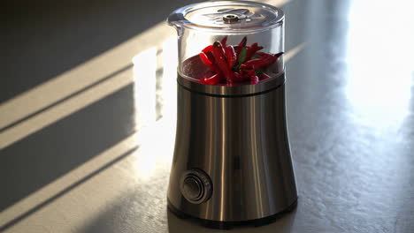 electric grinder filled with red chili peppers