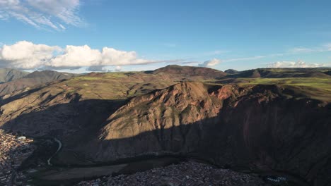 aerial of the town and mountains of urubamba, sacred valley, cusco, peru. drone pan shot