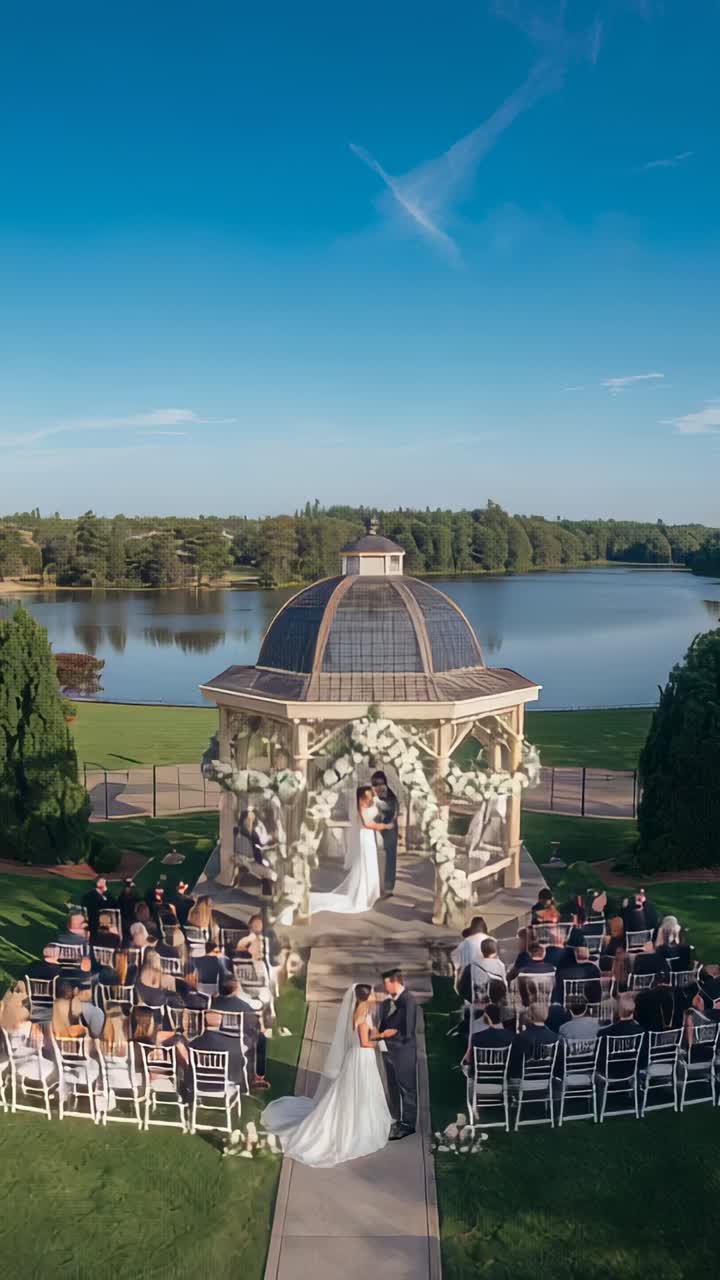 Video verticale: in risposta al segnale dell'officiante, sposa in abito e sposo che escono dal gazebo per i voti nuziali