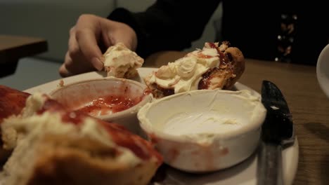 A plate of scones with clotted cream and jam, captured in a cozy dining setting