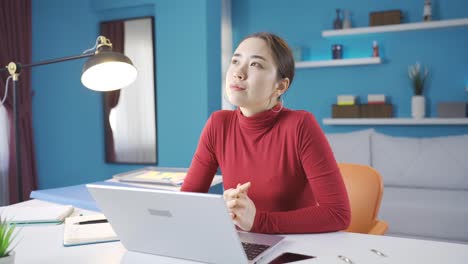 Eine-Junge-Asiatische-Frau-Beginnt-Darüber-Nachzudenken,-Was-Sie-Am-Laptop-Tun-Soll,-Und-Kommt-Dann-Auf-Eine-Gute-Idee.