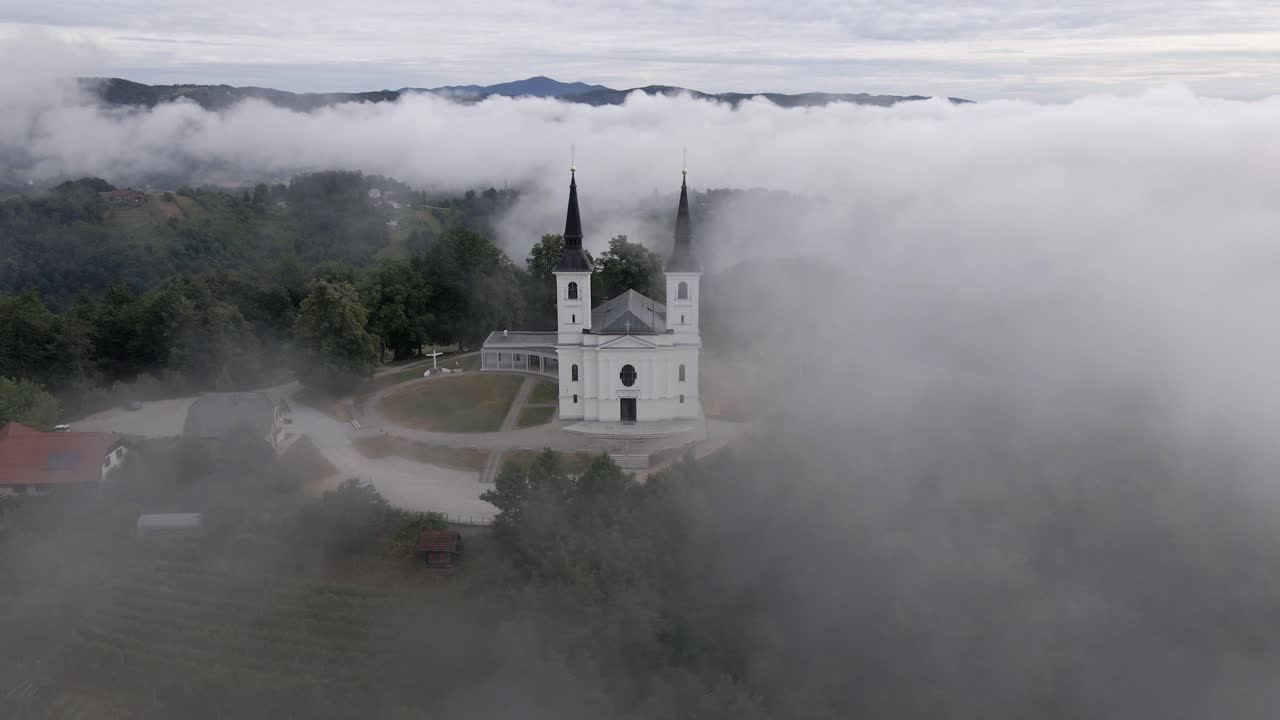 hermosa vista de la iglesia en la cima de la colina en la niebla