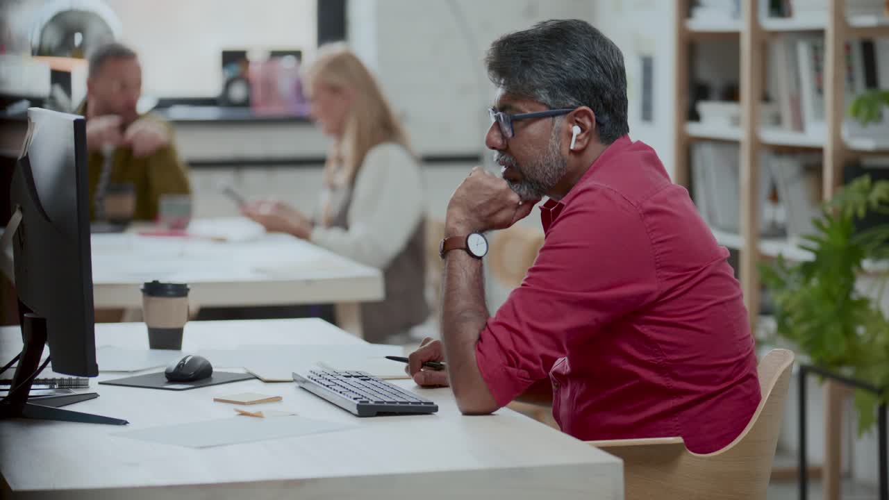 Indian Businessman Taking Notes during E-Meeting on Computer in Office
