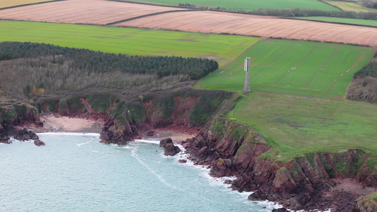 Vista aerea di una torre cellulare sulla cima dell'insenatura di Sleeping Bay, sulla costa frastagliata della campagna di Milford Haven.