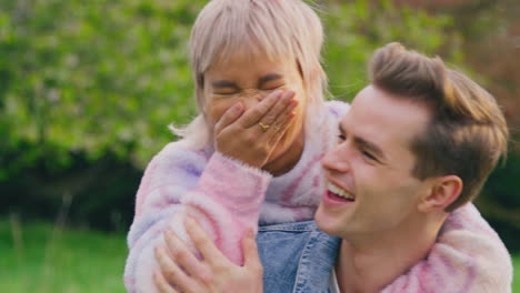 pareja amorosa al aire libre en el campo con el hombre dando a la mujer a cuestas