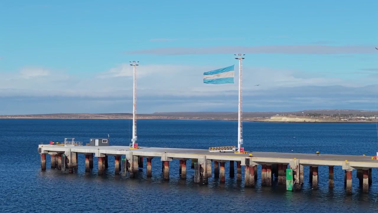 Dolly In de dron de la bandera argentina ondeando en el Muelle Piedra Buena, Puerto Madryn.
