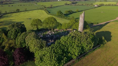 graveyard and round tower at monasterboice ruins in county louth, ireland. - aerial shot