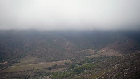 Llanuras-Cuesta-Abajo-Con-Exuberante-Vegetación-Cerca-Del-Campo-Contra-El-Cielo-Nublado