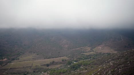 llanuras cuesta abajo con exuberante vegetación cerca del campo contra el cielo nublado
