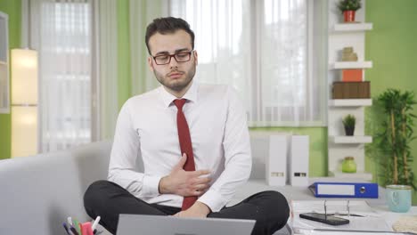 un hombre de negocios con dolor de estómago se retuerce de dolor.