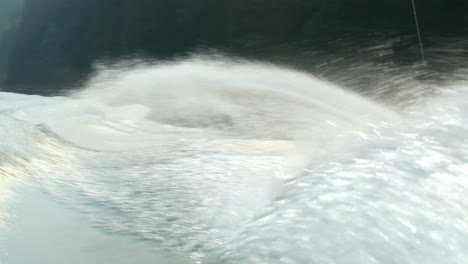 vista frontal de un joven caucásico haciendo trucos en wakeboard en el río de la ciudad 4k