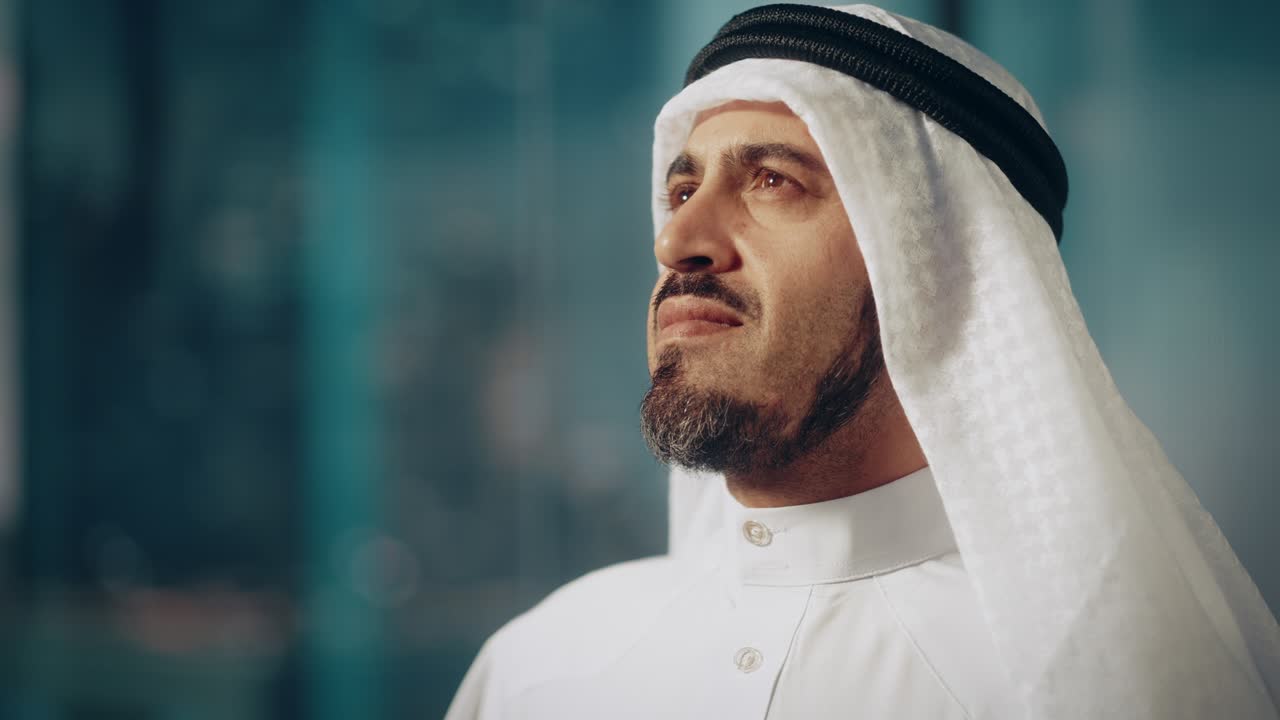 retrato de un exitoso empresario musulmán en traje tradicional sonriendo suavemente, con kandura blanca y agal negro manteniendo un ghutra en su lugar. concepto de empresario árabe saudí, emiratí.
