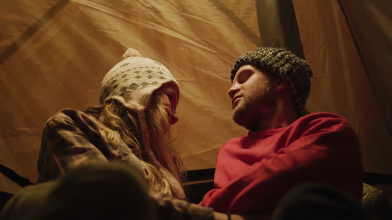 pareja caucásica acampando en la naturaleza por la noche