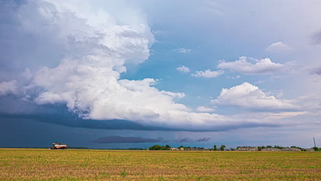 rain and cloudscape as tractors harvest crops - time lapse