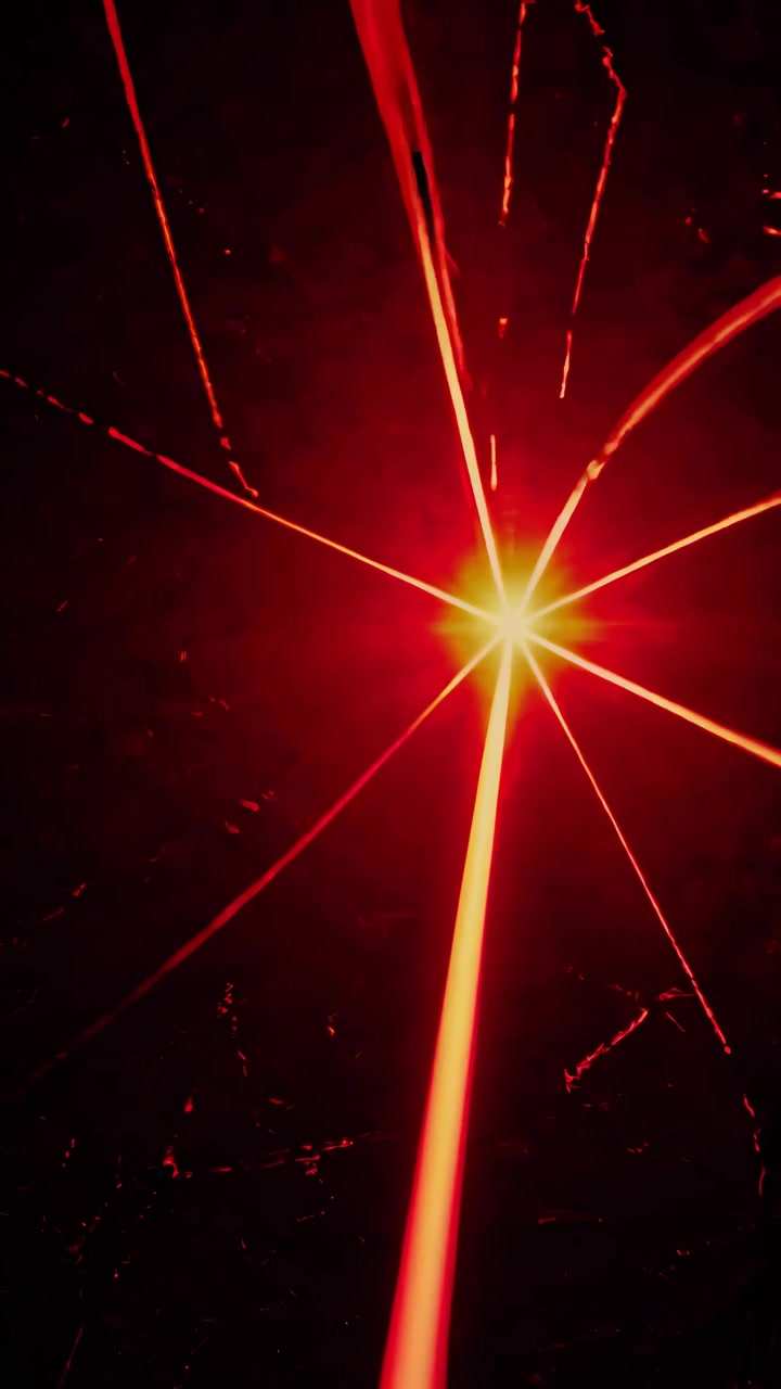 Sykkivät punaiset laser-valonsäteet tummalla taustalla