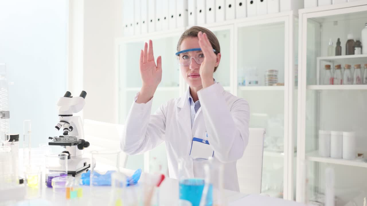 Female Scientist Puts on Safety Goggles in a Laboratory