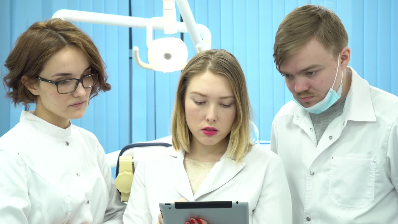 치과 팀이 태블릿에서 사건에 대해 논의하고 있습니다.