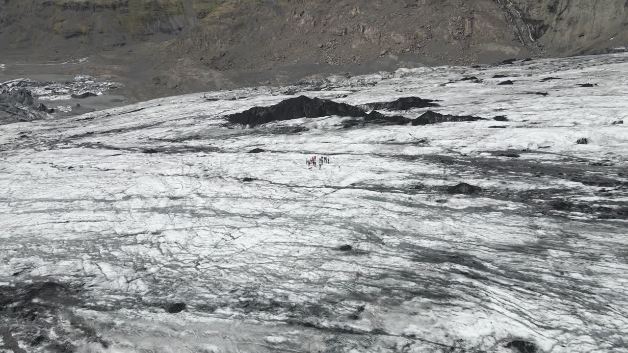 Ascend over S&oacute;lheimaj&ouml;kull glacier with an aerial drone, as the camera reveals the vast icy sprawl and towering mountains beyond, showcasing nature's grandeur and icy realm