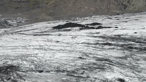 Ascienda-Sobre-El-Glaciar-Sólheimajökull-Con-Un-Dron-Aéreo,-Mientras-La-Cámara-Revela-La-Vasta-Extensión-Helada-Y-Las-Imponentes-Montañas-Más-Allá,-Mostrando-La-Grandeza-De-La-Naturaleza-Y-El-Reino-Helado.