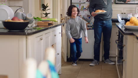 happy little boy running excited to eat waffles for breakfast with family enjoying weekend together with children in kitchen at home