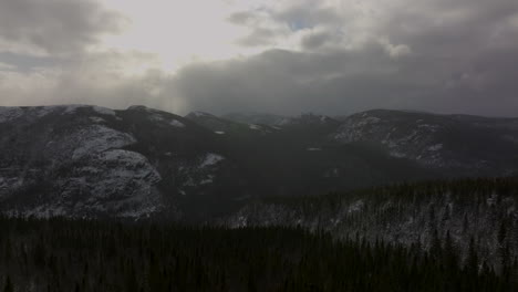 flyover lush thicket over mountains against clouded sky in mont du lac in l'empeche, quebec canada