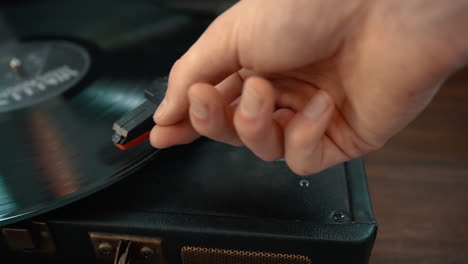 a close-up shot of a hand turning on a turntable and placing the needle on the record