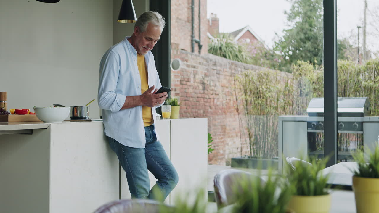 hombre usando el teléfono en la cocina